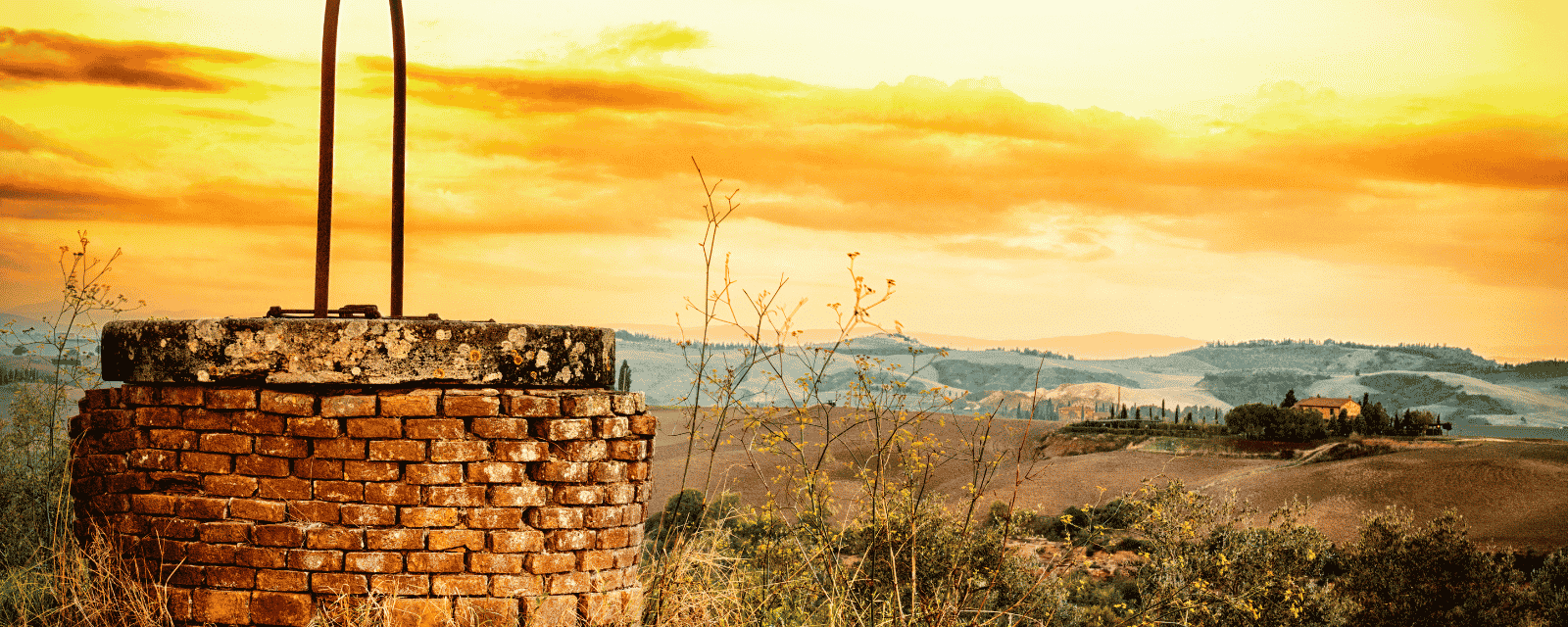 An old brick well at sunset
